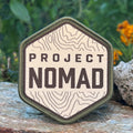 Project NOMAD woven patch with an olive merrow edge and a topographic contour design