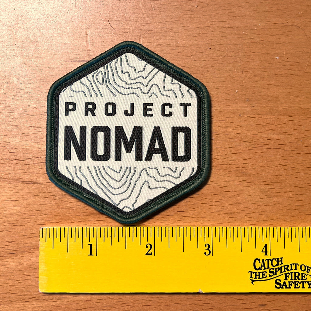 Project NOMAD patch next to a ruler, about 2.85 inches wide and 3.2 inches tall